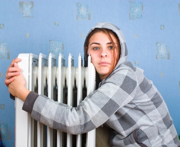 A menina congelante sobre um aquecedor — Fotografia de Stock
