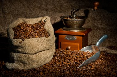 Sack of coffee beans, coffee-grinder and metal scoop still life clipart