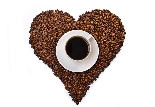 Tasse blanche de café sur les grains de café en forme de coeur — Photo