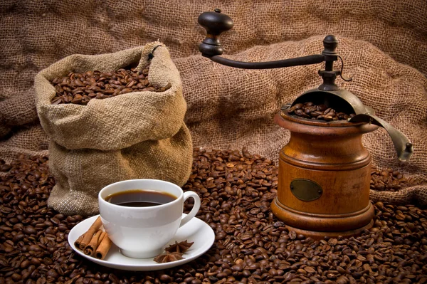 Saco de granos de café, taza blanca y naturaleza muerta molinillo de café —  Fotos de Stock