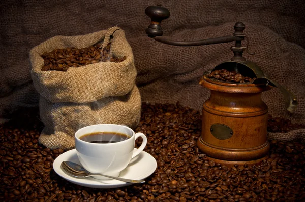 Zsák kávé bab, fehér kupa és kávédaráló csendélet — Stock Fotó