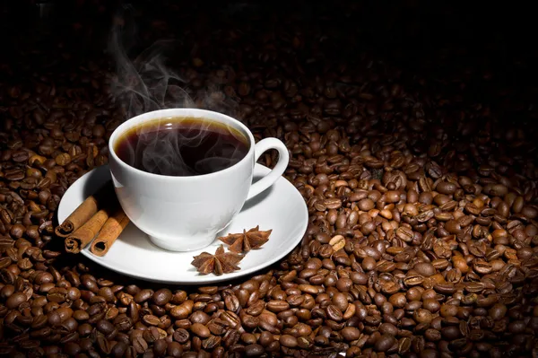 White cup of hot coffee on coffee beans — Stock Photo, Image