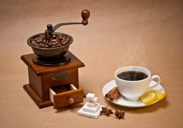 Młynek do kawy i filiżanki gorącej kawy — Zdjęcie stockowe