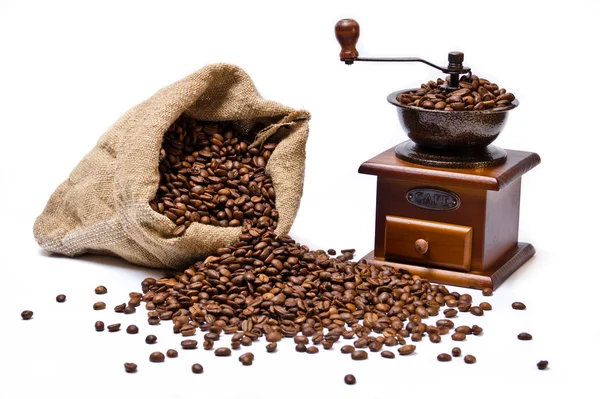 Saco de granos de café con granos dispersos y molinillo de café de madera —  Fotos de Stock