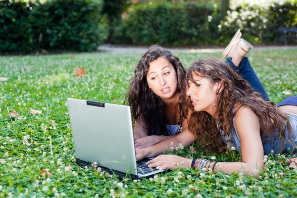 Две молодые женщины с топовым компьютером в парке — стоковое фото