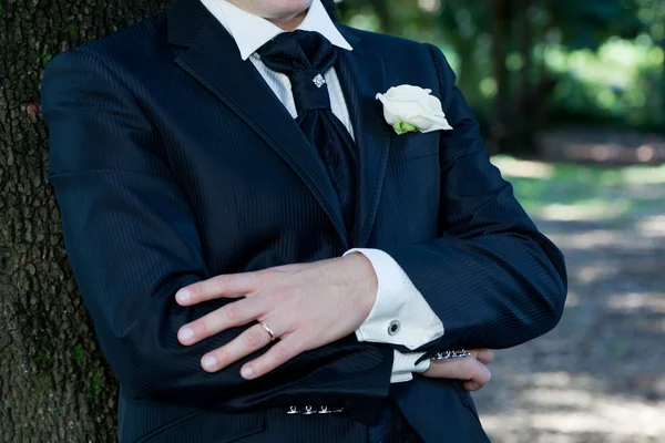Bruidegom met smoking en bruiloft bloem — Stockfoto