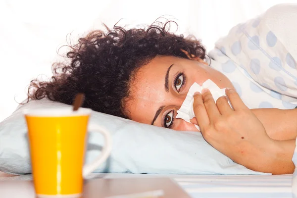 Joven mujer enferma acostada en la cama — Foto de Stock
