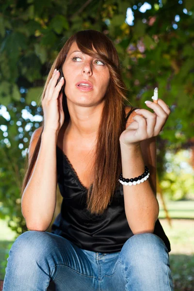 Stock image Young Woman Talk on the Phone and Smoke