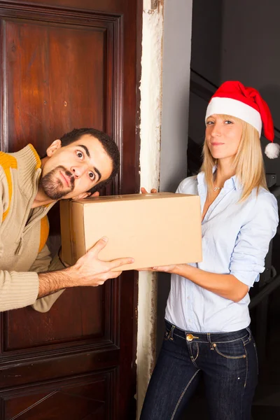 Hombre recibe una caja de mujer joven con sombrero de Navidad —  Fotos de Stock