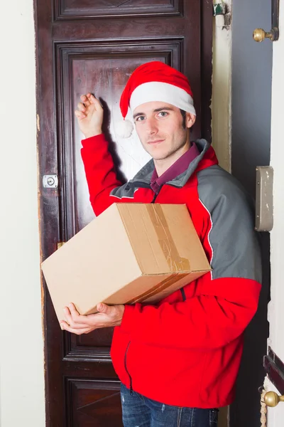 クリスマスの帽子との配達の少年はドアをノックします。 — ストック写真
