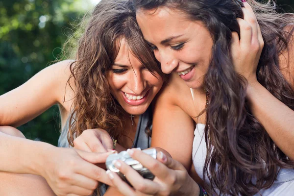 Twee meisjes in het park op zoek foto's in de camera — Stockfoto