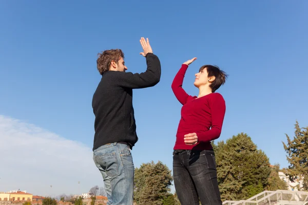 Молодой человек с женщиной прыгает и дает пять — стоковое фото