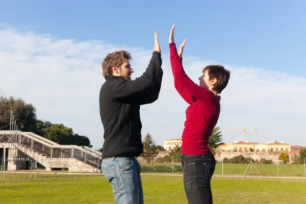 Young Man with Woman Jumping and Giving High Five — Stock Photo, Image
