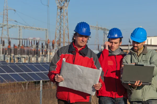 Ingenjörer vid arbete i en solenergianläggning — Stockfoto