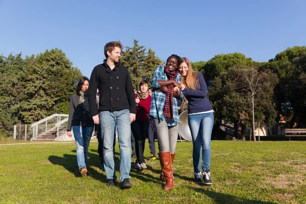 Estudantes universitários caminhando e conversando no parque — Fotografia de Stock