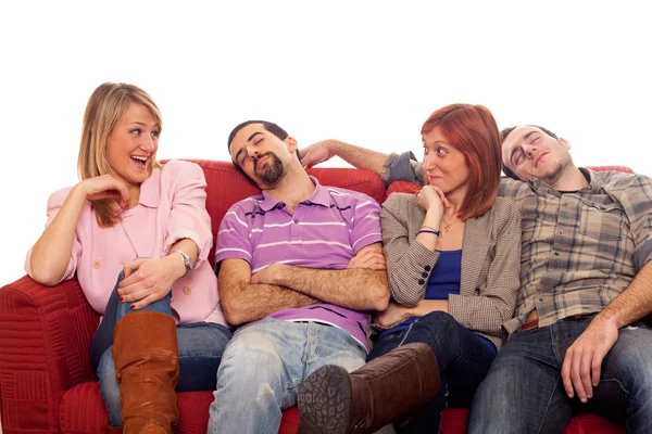 Девушки смеются, пока мальчики спят на диване — стоковое фото