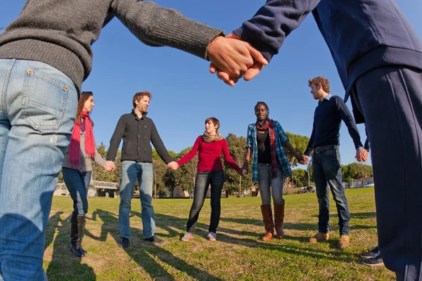 Multiracial joven sosteniendo las manos en un círculo —  Fotos de Stock