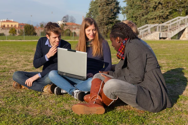 Étudiants au collège avec ordinateur au parc — Photo