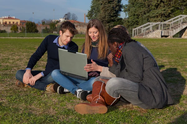 Студенты колледжа с компьютером в парке — стоковое фото