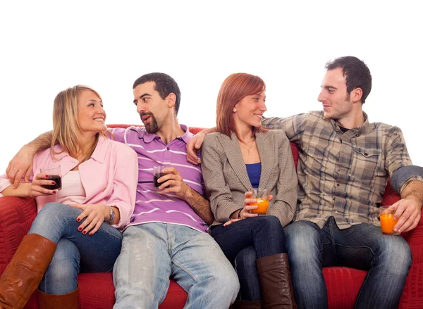 Mladá skupina, sedí na pohovce a pití — Stock fotografie