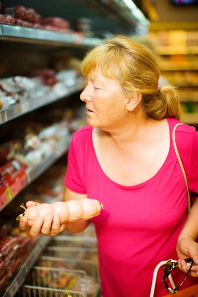 Dona de casa comprando salsicha — Fotografia de Stock