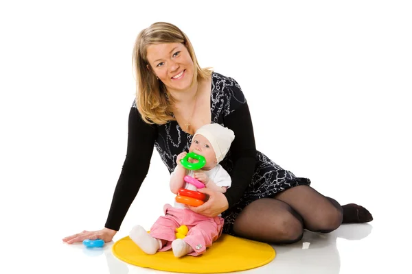 免震床の上に座っての赤ちゃんと遊ぶ母 — ストック写真