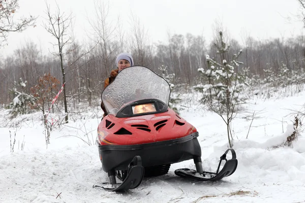 Vrouw sneeuwscooter rijden — Stockfoto