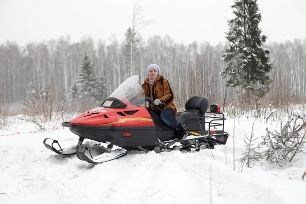 森林にスノーモービルを運転ロシア人女性 — ストック写真