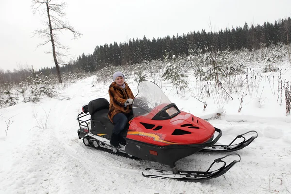 Woman is posing on snowmobile — Stock Photo, Image