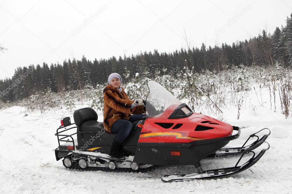 Woman on red snowmobile