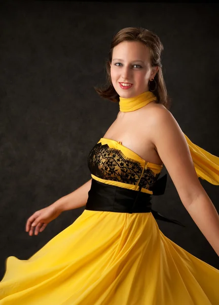 Jonge vrouw in een gele jurk — Stockfoto