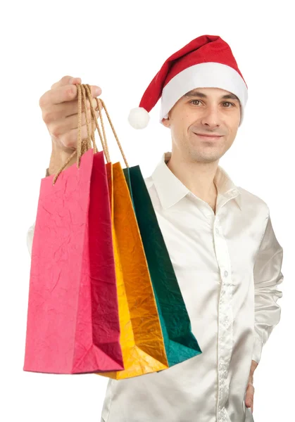 Hombres jóvenes en sombrero rojo de Navidad con bolsas de regalos de papel — Foto de Stock