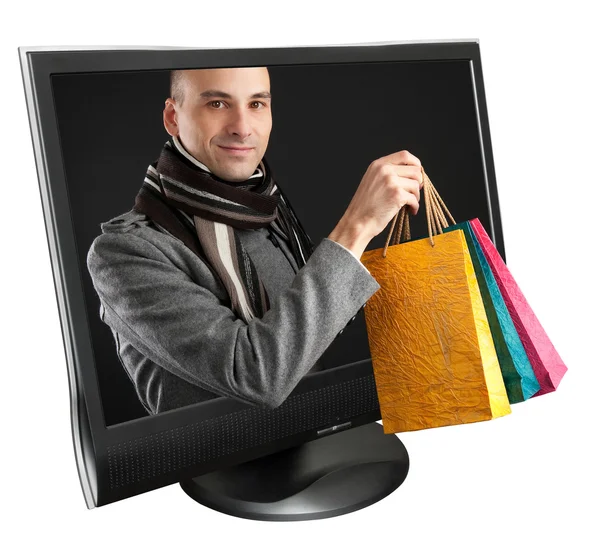 Young man with paper bags in a computer monitor — Stock Photo, Image