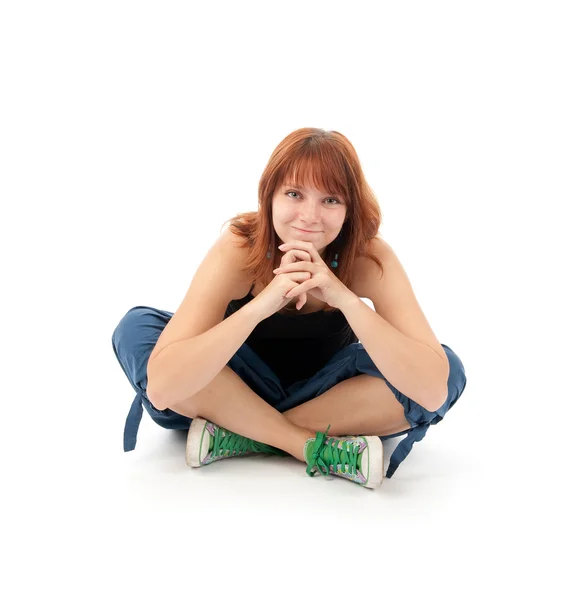 Счастливая молодая женщина сидит расслабленно на полу — стоковое фото