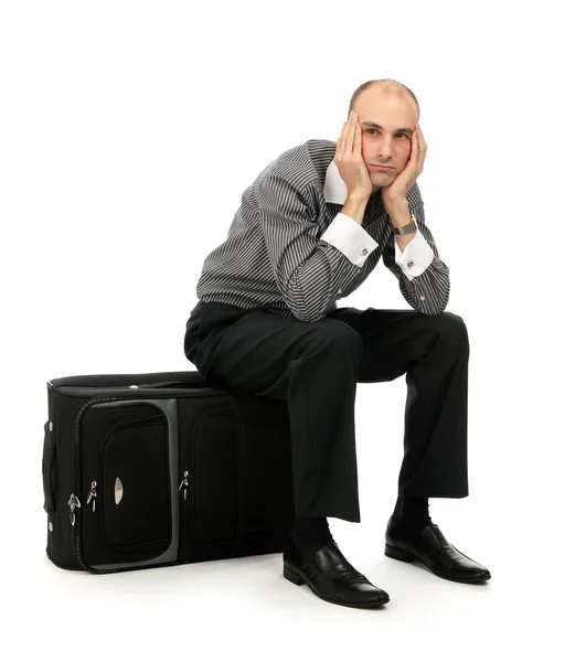 Красивый молодой человек сидит на своем багаже — стоковое фото