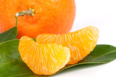 Ripe tangerines with leaves and slices on white background clipart