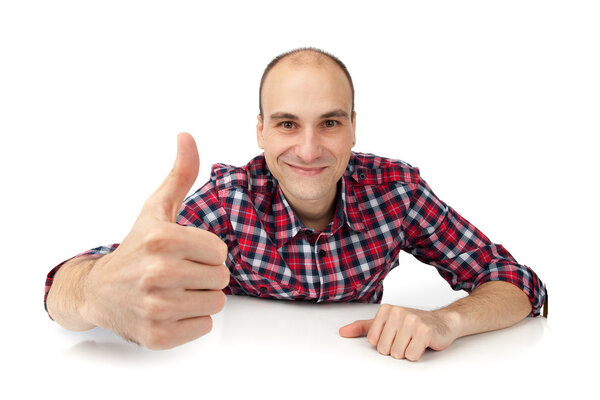 Счастливый случайный молодой человек показывая большой палец вверх и улыбаясь изолированы на белом фоне

