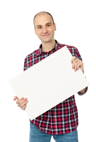 Feliz joven guapo sosteniendo la tarjeta blanca en blanco —  Fotos de Stock