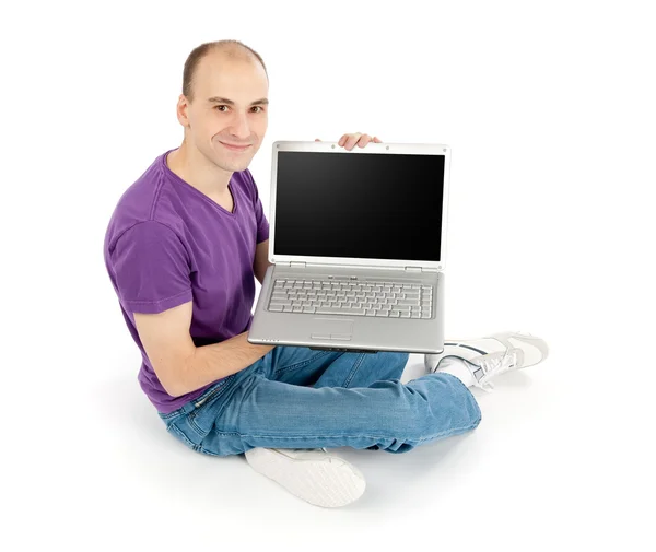 Boş ekran dizüstü bilgisayarınızla tutan genç adam — Stok fotoğraf