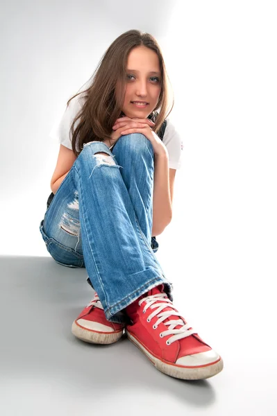 Jong meisje zit op de vloer — Stockfoto