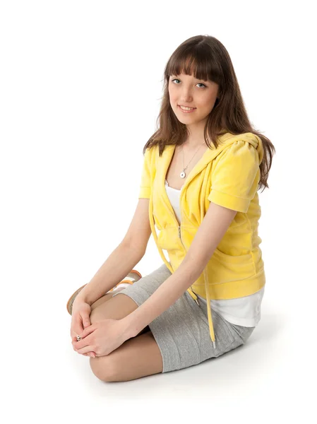 Mladá žena sedící na bílém pozadí — Stock fotografie