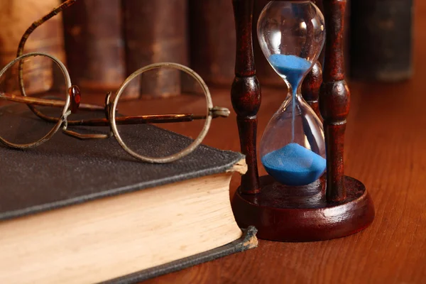 Пісочний годинник і старі книги — стокове фото