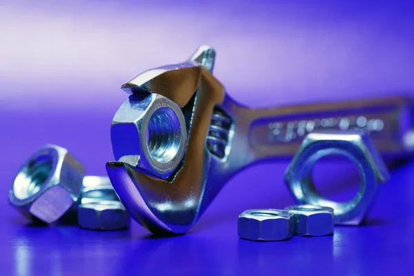 Extreme Nahaufnahme Eines Verstellbaren Schlüssels Der Eine Schraubenmutter Auf Blauem — Stockfoto