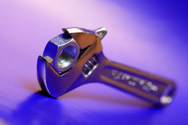 Ακραία Closeup Ρυθμιζόμενο Γαλλικό Κλειδί Πιάνοντας Ένα Παξιμάδι Μπλε Και — Φωτογραφία Αρχείου