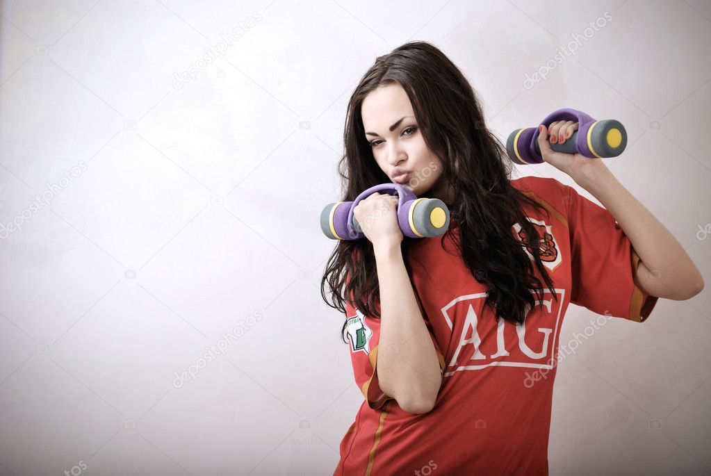 Attractive young athlete with dumbbell