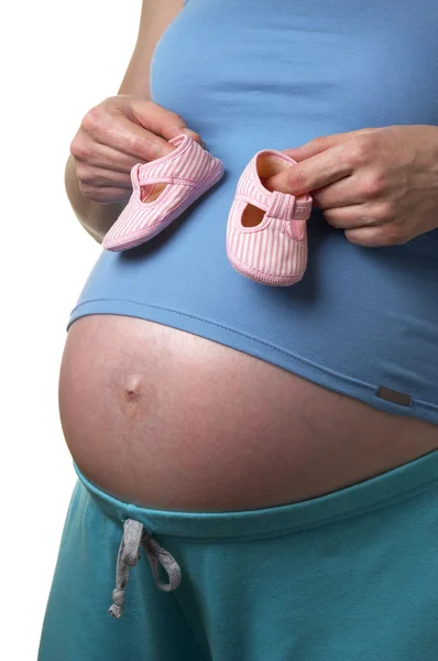 白い背景の上の手の中の小さな靴と妊娠中の女性のプロファイル — ストック写真