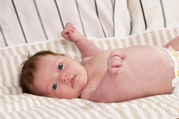 Nyfödd Baby Flicka Över Mjuk Randig Handduk Royaltyfria Stockbilder