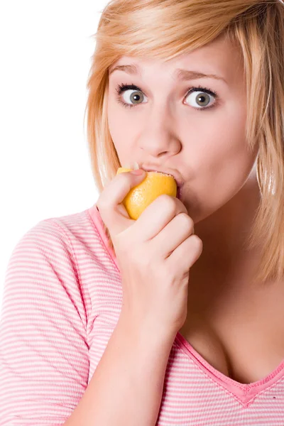 Молодая девушка ест лимон — стоковое фото