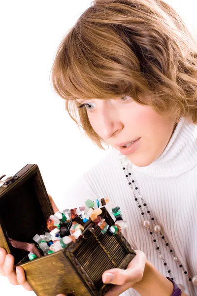 Beautiful girl looks at wooden jewelry box — Stock Photo, Image