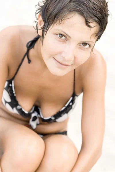 Brunet 女人坐在沙滩上 — 图库照片